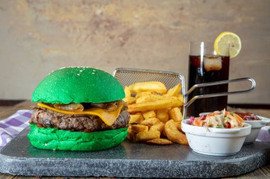 Yeşil burger, ahşap arka planda yeşil çörekli hamburger. Metin için yer.