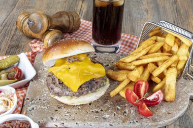 Köfteli, domatesli, peynirli, marullu ve mayonezli lezzetli hamburgerler tezgahın kırsal ahşap bir masasında, fotokopi alanı ile servis edilir..