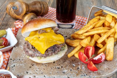 Köfteli, domatesli, peynirli, marullu ve mayonezli lezzetli hamburgerler tezgahın kırsal ahşap bir masasında, fotokopi alanı ile servis edilir..