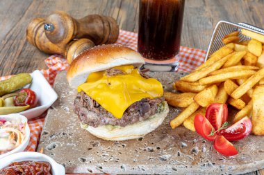 Köfteli, domatesli, peynirli, marullu ve mayonezli lezzetli hamburgerler tezgahın kırsal ahşap bir masasında, fotokopi alanı ile servis edilir..