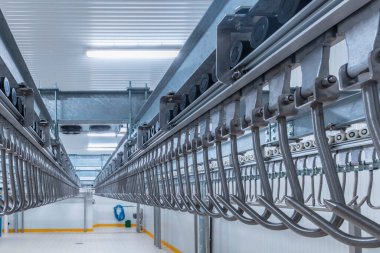 Et asma kancası. Soğuk hava deposunun içindeki endüstriyel yükleme alanı. Demiryolunda asılı duran et kancaları..