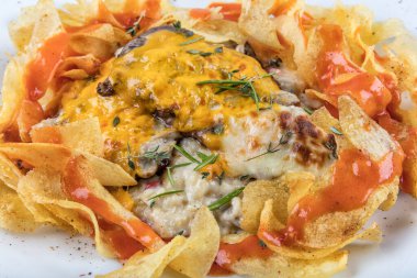 Fast food konsepti, peynirli kızarmış et ve patates cipsiyle süslenmiş sos.