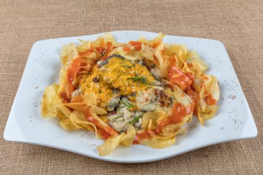 Fast food konsepti, peynirli kızarmış et ve patates cipsiyle süslenmiş sos.