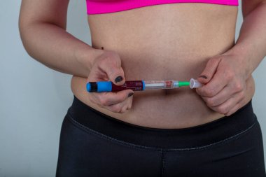 İstanbul, Türkiye - 06 Mart 2019; diyabet hastaları için bir ilaçtan çıkan Victoza insülin grubu. Diyabet ilaçları. Kadın mideye insülin enjekte ediyor, yakın plan. Diyabet Hastalığı.