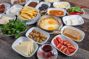 Geleneksel Türk kahvaltı tabağı gri ahşap masa, üst manzara. Parlak sabahlarda sağlıklı Türk kahvaltısı; metin için boşluk kopyala.