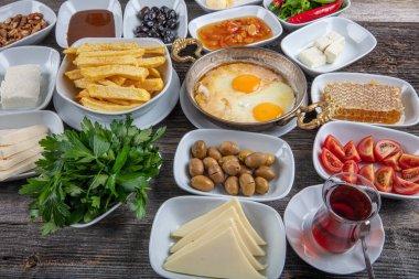 Geleneksel Türk kahvaltı tabağı gri ahşap masa, üst manzara. Parlak sabahlarda sağlıklı Türk kahvaltısı; metin için boşluk kopyala.