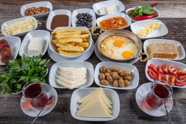 Geleneksel Türk kahvaltı tabağı gri ahşap masa, üst manzara. Parlak sabahlarda sağlıklı Türk kahvaltısı; metin için boşluk kopyala.