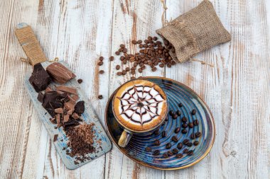 Ahşap masadaki Latte sanatı. Bir fincan kahve, kapuçino sanatı, kapuçino..