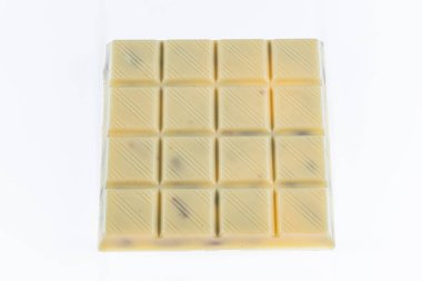 Beyaz çikolata seti Kırık çikolata, beyaz çikolata, tablet çikolata ve beyaz arka planda saklı şam fıstığı