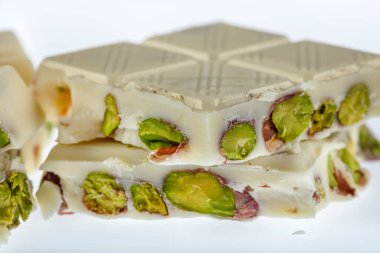 Beyaz çikolata seti Kırık çikolata, beyaz çikolata, tablet çikolata ve beyaz arka planda saklı şam fıstığı