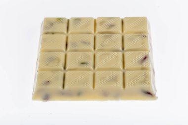 Kırık beyaz çikolata, beyaz arka planda izole edilmiş fıstıklı beyaz çikolata..