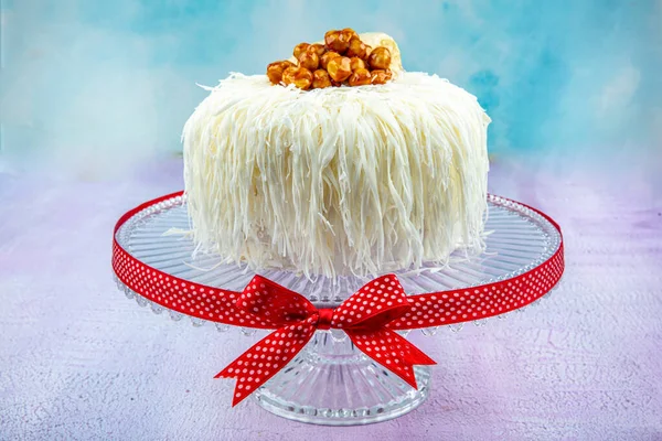 Beyaz çikolatalı muzlu kek (sacakli yas pasta). Pembe ahşap arka planda. Pastane konsepti.