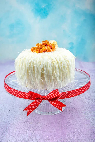 Beyaz çikolatalı muzlu kek (sacakli yas pasta). Pembe ahşap arka planda. Pastane konsepti.