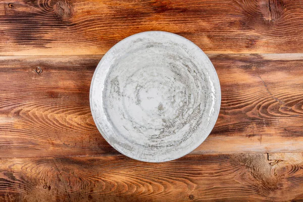 木製のテーブルの上に白い盛り付けプレート 古い木製の背景に空のプレート トップ表示 — ストック写真