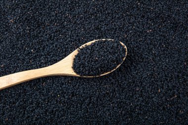 Siyah kimyon. Nigella sativa tohumu dokusu. Kara kimyon temel yağı, Nigella Sativa siyah kimyon yığınında kaşık içinde. Birçok hastalık için organik bitkisel ilaç.