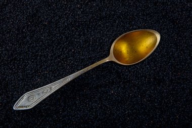 Siyah kimyon. Nigella sativa tohumu dokusu. Kara kimyon temel yağı, Nigella Sativa siyah kimyon yığınında kaşık içinde. Birçok hastalık için organik bitkisel ilaç.