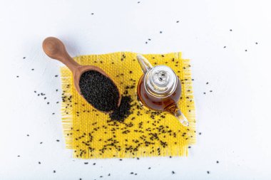 Siyah kimyon tohumları ve kase, tahta kürek ya da kaşık ile gerekli yağ. Nigella Sativa cam şişede. Birçok hastalık için organik bitkisel ilaç.