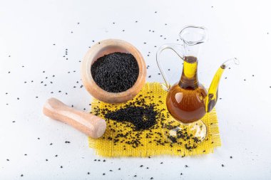 Siyah kimyon tohumları ve kase, tahta kürek ya da kaşık ile gerekli yağ. Nigella Sativa cam şişede. Birçok hastalık için organik bitkisel ilaç.