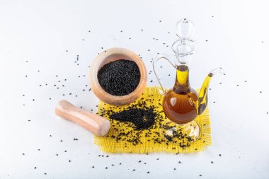 Siyah kimyon tohumları ve kase, tahta kürek ya da kaşık ile gerekli yağ. Nigella Sativa cam şişede. Birçok hastalık için organik bitkisel ilaç.