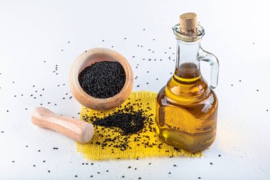 Siyah kimyon tohumları ve kase, tahta kürek ya da kaşık ile gerekli yağ. Nigella Sativa cam şişede. Birçok hastalık için organik bitkisel ilaç.