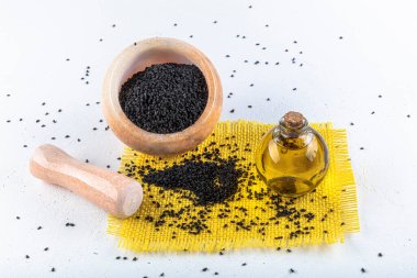 Siyah kimyon tohumları ve kase, tahta kürek ya da kaşık ile gerekli yağ. Nigella Sativa cam şişede. Birçok hastalık için organik bitkisel ilaç.