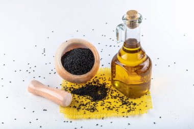 Siyah kimyon tohumları ve kase, tahta kürek ya da kaşık ile gerekli yağ. Nigella Sativa cam şişede. Birçok hastalık için organik bitkisel ilaç.