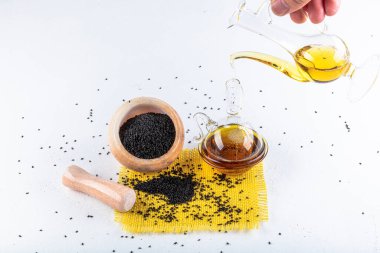 Siyah kimyon tohumları ve kase, tahta kürek ya da kaşık ile gerekli yağ. Nigella Sativa cam şişede. Birçok hastalık için organik bitkisel ilaç.