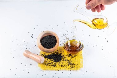 Siyah kimyon tohumları ve kase, tahta kürek ya da kaşık ile gerekli yağ. Nigella Sativa cam şişede. Birçok hastalık için organik bitkisel ilaç.