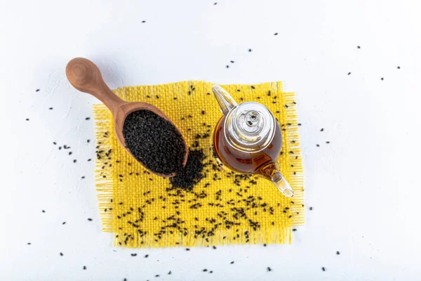 Siyah kimyon tohumları ve kase, tahta kürek ya da kaşık ile gerekli yağ. Nigella Sativa cam şişede. Birçok hastalık için organik bitkisel ilaç.