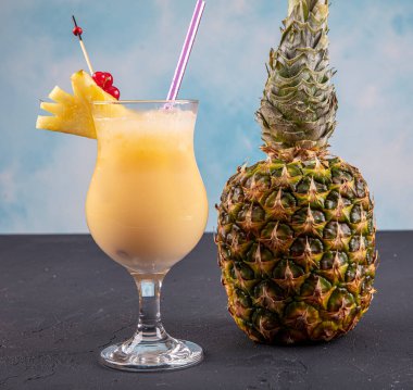 Ahşap arka planda süslü ananaslı Pina Colada. Bir kokteyl 