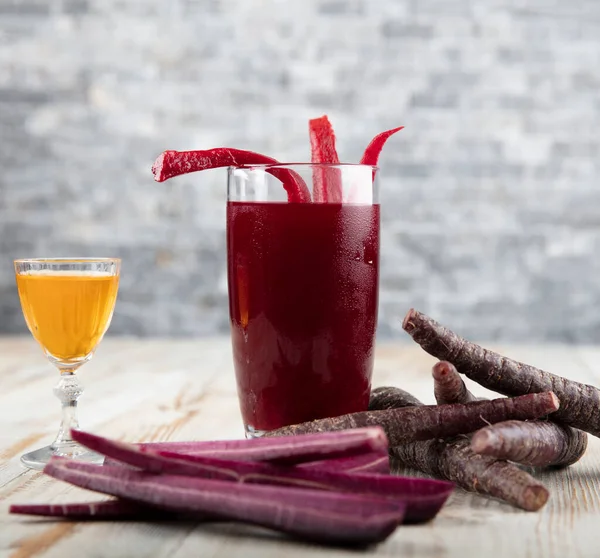 Traditional turkish drink turnip juice (Salgam). Drink Salgam, red carrot and turnip juice on a wooden background.