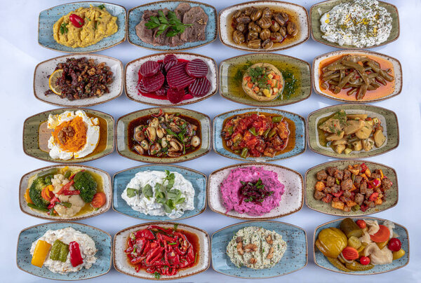 Traditional Turkish and Greek dinner meze table. Turkish Cuisine Cold Appetizers (appetizers with olive oil). Turkish appetizers in colorful plates. yogurt and various boiled herbs