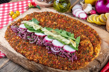 Lezzetli Türk pizzası lahmacun, ahşap masaya yakın plan. Limonlu salata ve ayran ile. Beyaz arka planda yeşil sebzeler arasında Türk Lahmacunu. Lahmacun Restoranı konsepti.