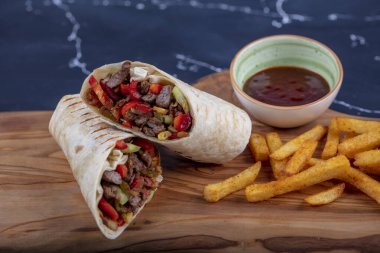 Et ambalajı; Türkçe adı, Et Durum. Yumuşak dilimlenmiş biftek, kırmızı biber ve salata süslemeleri ile kaplı tortilla, arka planda fotokopi alanı ile kaplanmış.