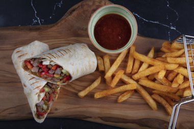 Et ambalajı; Türkçe adı, Et Durum. Yumuşak dilimlenmiş biftek, kırmızı biber ve salata süslemeleri ile kaplı tortilla, arka planda fotokopi alanı ile kaplanmış.