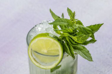 Mojito kokteyli uzun süre içilir geleneksel Küba taze tropikal içecek üst görünüm kopyalama alanı iki viski bardağı, rom, nane, limon suyu, soda ve buz beyaz beton masa üzerinde..