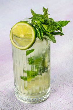 Mojito kokteyli uzun süre içilir geleneksel Küba taze tropikal içecek üst görünüm kopyalama alanı iki viski bardağı, rom, nane, limon suyu, soda ve buz beyaz beton masa üzerinde..