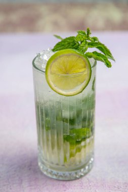 Mojito kokteyli uzun süre içilir geleneksel Küba taze tropikal içecek üst görünüm kopyalama alanı iki viski bardağı, rom, nane, limon suyu, soda ve buz beyaz beton masa üzerinde..