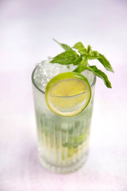 Mojito kokteyli uzun süre içilir geleneksel Küba taze tropikal içecek üst görünüm kopyalama alanı iki viski bardağı, rom, nane, limon suyu, soda ve buz beyaz beton masa üzerinde..