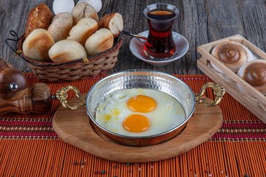 Türk kahvaltısı, bakır tarlasında Türk usulü göz yumurtası. Bakır tavada tereyağı ve yumurta.
