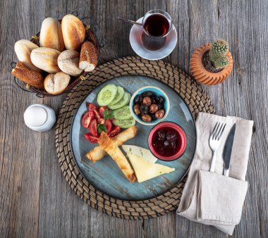 Geleneksel Türk kahvaltı tabağı gri ahşap masa, üst manzara. Parlak sabahlarda sağlıklı Türk kahvaltısı; metin için boşluk kopyala.