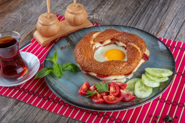 Çörek, yumurta, salatalık ve domateslerden oluşan lezzetli bir kahvaltı tabağı..