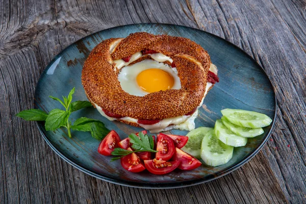 Çörek, yumurta, salatalık ve domateslerden oluşan lezzetli bir kahvaltı tabağı..