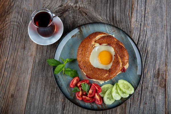 Çörek, yumurta, salatalık ve domateslerden oluşan lezzetli bir kahvaltı tabağı..