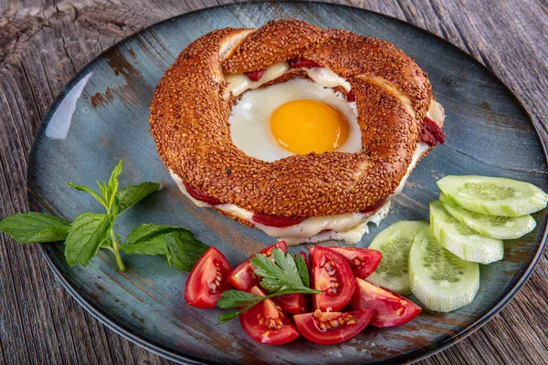 Çörek, yumurta, salatalık ve domateslerden oluşan lezzetli bir kahvaltı tabağı..