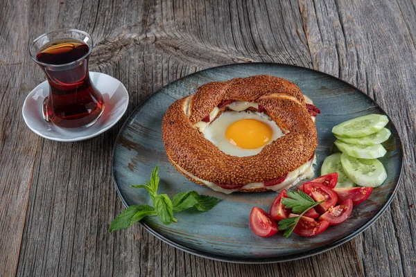 Çörek, yumurta, salatalık ve domateslerden oluşan lezzetli bir kahvaltı tabağı..