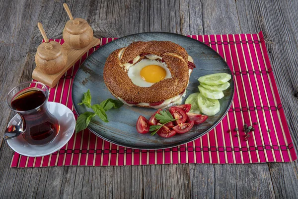 Çörek, yumurta, salatalık ve domateslerden oluşan lezzetli bir kahvaltı tabağı..
