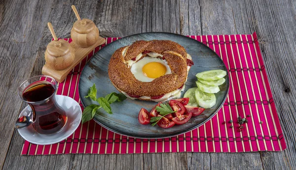 Çörek, yumurta, salatalık ve domateslerden oluşan lezzetli bir kahvaltı tabağı..