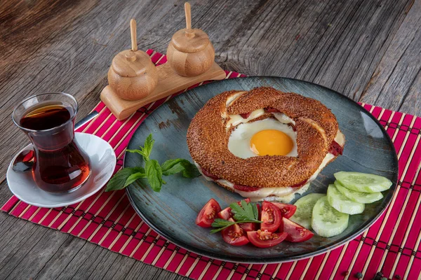 Çörek, yumurta, salatalık ve domateslerden oluşan lezzetli bir kahvaltı tabağı..