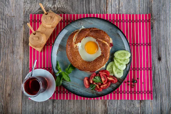 Çörek, yumurta, salatalık ve domateslerden oluşan lezzetli bir kahvaltı tabağı..